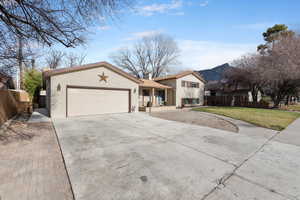 Split level home featuring concrete driveway, brick siding, and a garage