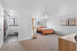 Bedroom with light colored carpet, ornamental molding, ceiling fan, and connected bathroom