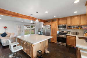 Kitchen with open shelves, stainless steel appliances, recessed lighting, open floor plan, and decorative light fixtures