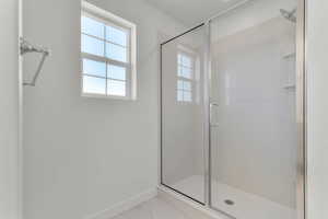 Full bath with a shower stall and light marble finish flooring