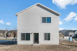 Back of house featuring stucco siding and a residential view