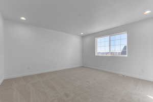 Spare room featuring light carpet and recessed lighting