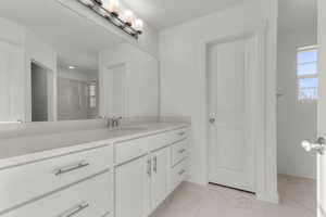Full bathroom with vanity, light marble finish flooring, a stall shower, and a textured ceiling