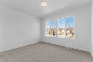 Unfurnished room featuring carpet and a residential view