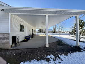 Snow covered patio featuring a patio, area for grilling, and a ceiling fan