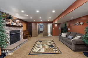 Living room with light colored carpet, a fireplace, stairway, and recessed lighting