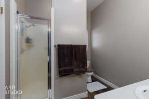 Full bathroom with vanity, a stall shower, and dark wood finished floors