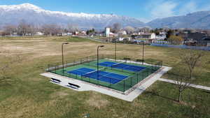 View of sport court with a pickleball court, a mountain view, a residential view, and a patio