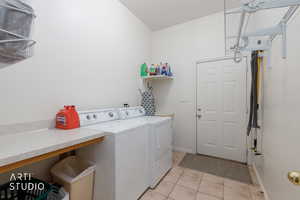 Laundry area with light tile patterned floors and washing machine and dryer