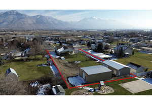 Aerial perspective of suburban area with property boundaries highlighted and a mountainous background