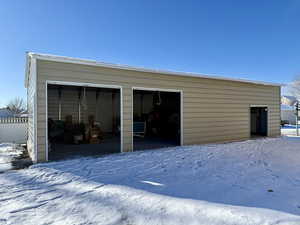 Snow covered garage featuring a garage