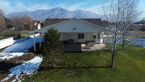 Rear view of property with a mountain view and a patio area