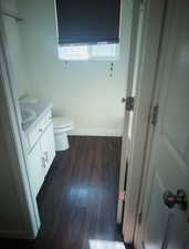 Half bath featuring dark wood finished floors and vanity