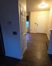 Corridor with baseboards and dark wood-type flooring