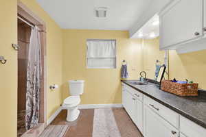 Full bath featuring light tile patterned floors, vanity, and curtained shower
