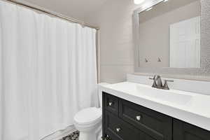 Full bath with vanity and wood walls