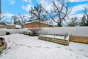 Yard layered in snow with a deck and a fenced backyard