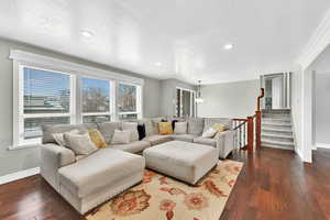 Living area featuring stairway, a textured ceiling, dark wood-style floors, and recessed lighting
