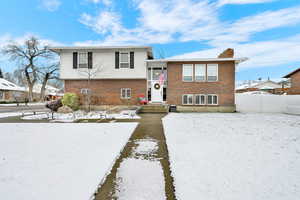Split level home featuring brick siding and a chimney