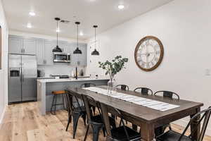 Dining space with light wood finished floors and recessed lighting