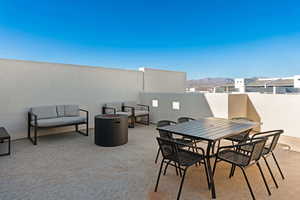 View of patio with a fire pit, a mountain view, and outdoor dining area