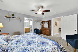 Bedroom featuring ceiling fan, carpet floors, and connected bathroom