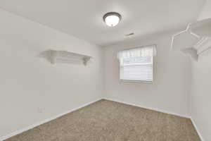 Spare room featuring carpet flooring and baseboards