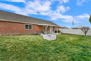 Rear view of house featuring a patio area, brick siding, and a shingled roof