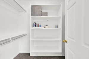 Walk in closet featuring dark carpet