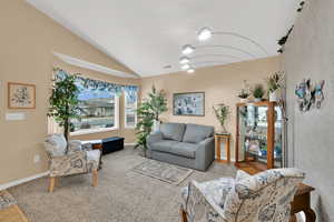 Living room with vaulted ceiling and carpet flooring