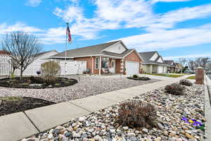 Ranch-style home with brick siding, a shingled roof, a gate, concrete driveway, and a garage
