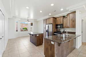 Kitchen featuring two islands with granite countertops, wood cabinetry, stainless steel appliances, and tile flooring