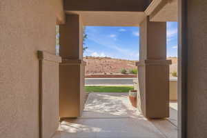 Covered entryway featuring textured stucco walls and square columns