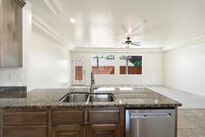 Kitchen island featuring a dual-basin stainless steel sink, granite-finish countertop, stainless steel dishwasher, and wood-finish cabinetry