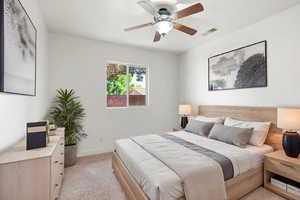 Spacious room featuring light-toned walls, a window with exterior views, and a ceiling fan with integrated lighting