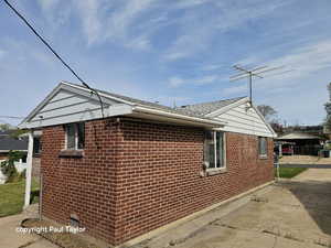 View of property exterior with brick siding