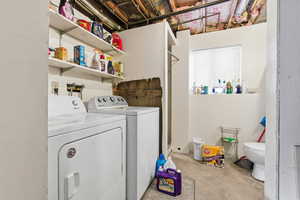 Laundry area featuring unfinished concrete flooring and washing machine and clothes dryer