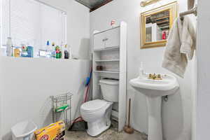 Bathroom featuring toilet and concrete flooring