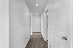 Corridor with light carpet, recessed lighting, and attic access