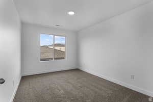 Empty room featuring light carpet and baseboards