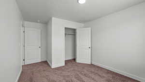 Unfurnished bedroom featuring carpet flooring and a closet
