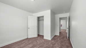 Unfurnished bedroom with dark carpet, a closet, and a textured ceiling