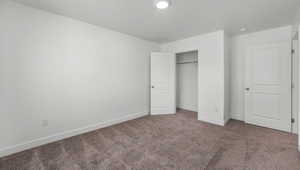 Unfurnished bedroom featuring carpet and a closet