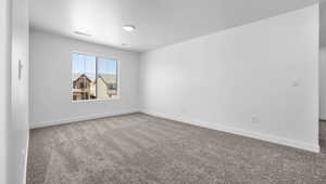 Spare room with carpet flooring and a textured ceiling