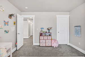 Carpeted bedroom featuring baseboards