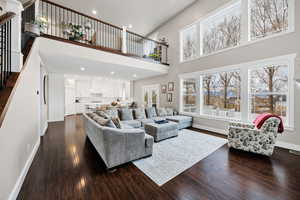 Kitchen Family room with a high ceiling, stairway, recessed lighting, and dark wood finished floors