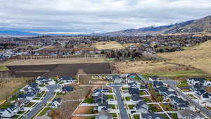 Aerial view of property and surrounding area with nearby suburban area and mountains