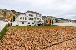 Rear view of property with a fenced backyard, stairway, and a mountain view