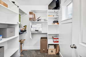 Walk in closet with dark colored carpet