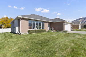 Ranch-style home with an attached garage, brick siding, concrete driveway, and roof with shingles